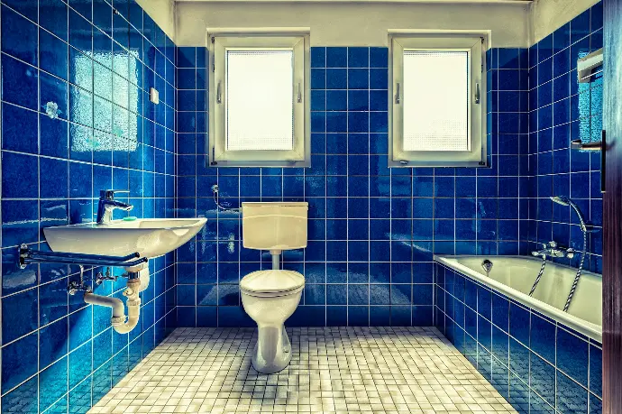 white ceramic sink beside blue wall tiles